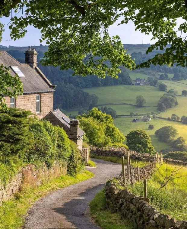 A lane winding down through the Cotswold hills